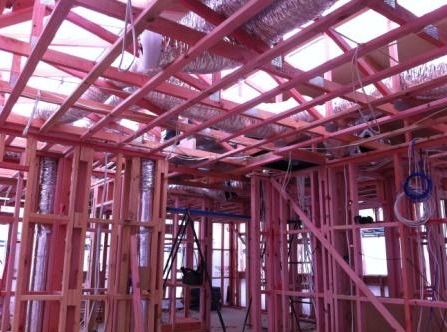 Rigid ductwork run within the walls of a two-level house