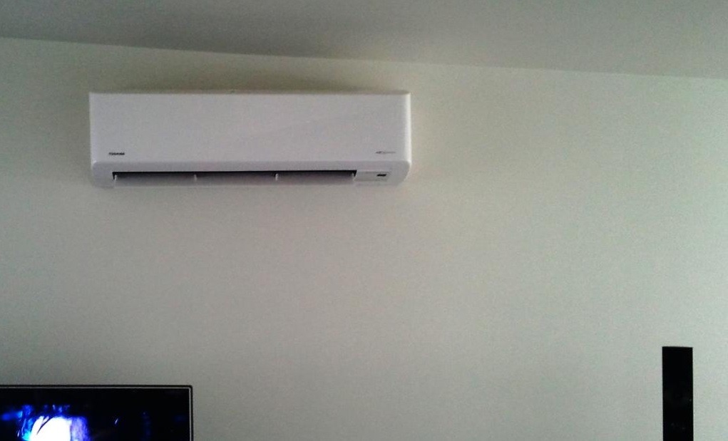 High-wall Toshiba heat pump installed in a new-build living room